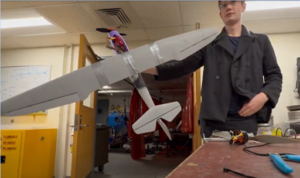 student holding airplane